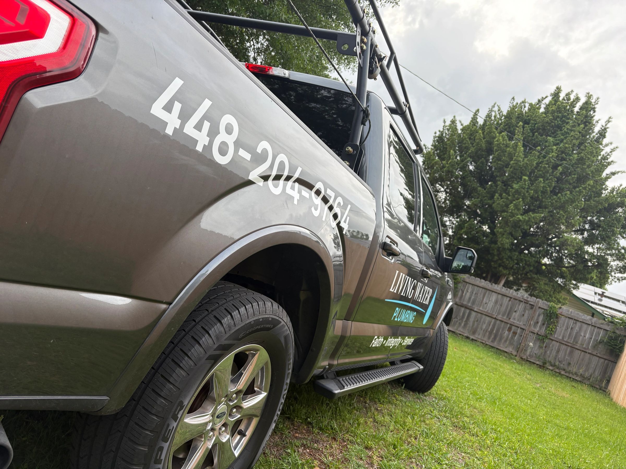 Living Water Plumbing service truck with phone number 448-204-9764